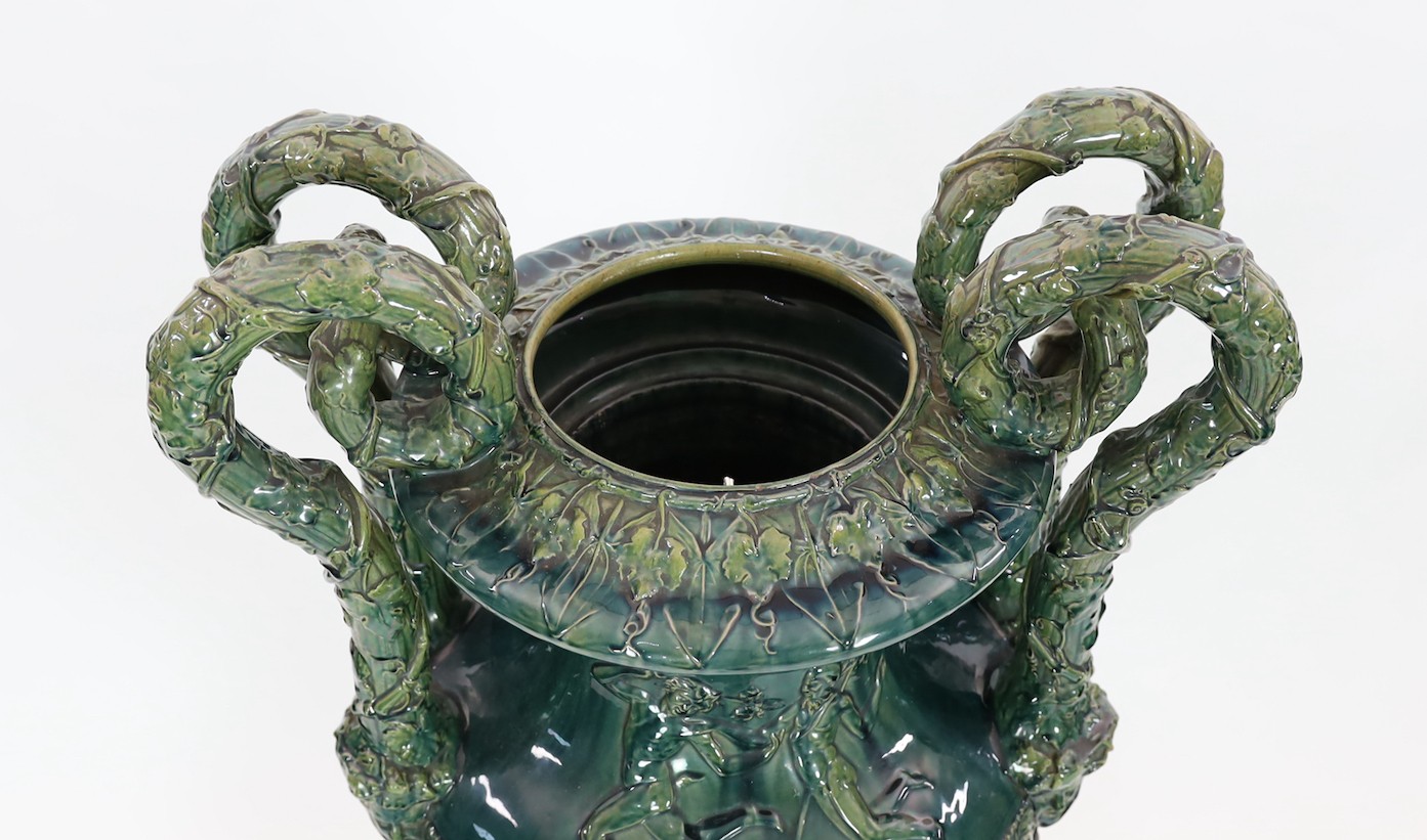 A massive Continental majolica green glazed campana vase and associated stand, late 19th century, total height 153cm, small repairs